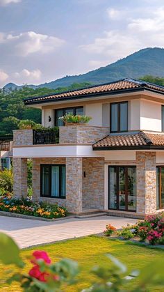 this is a nice house with beautiful landscaping and mountains in the backgrouund