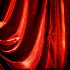 the curtain is red and shiny with some light