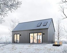 a small metal building sitting on top of a snow covered field with trees in the background