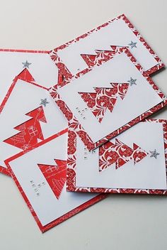 four red and white christmas cards with silver stars on the top one is folded in half