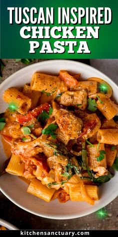 a white plate topped with pasta covered in sauce and chicken meat, on top of a wooden table