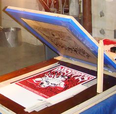 an art work is being displayed on a table in front of a glass window with blue frame