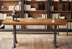 a wooden table sitting in front of a book shelf filled with books