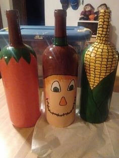 three wine bottles painted with corn on the cob