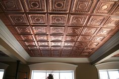 a living room filled with furniture and a ceiling covered in metal tining tiles on the ceiling