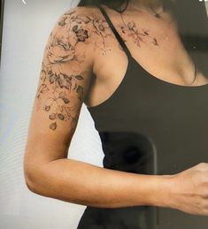 a woman with tattoos on her arm holding a cell phone