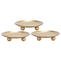 three gold plates with handles on each one and the other in different sizes, all sitting side by side