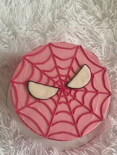 a spider - man cake is decorated with pink frosting