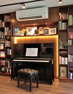 there is a piano in front of the bookshelves