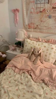 a teddy bear sitting on top of a bed in a room with pink and white decor