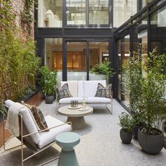 a living room filled with furniture and lots of plants