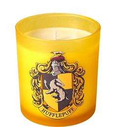 a yellow harry potter candle with hogwart's crest on the front and side