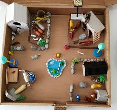 an open cardboard box filled with lots of toys and decorations on top of a table