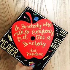 someone is holding up a graduation cap with writing on it