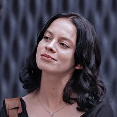 a woman wearing a black shirt and brown backpack