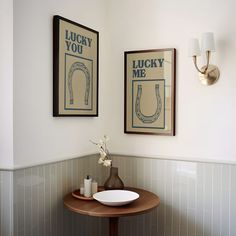 two framed pictures hang on the wall above a sink