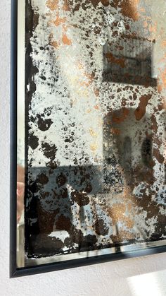 the reflection of a person standing in front of a wall with peeling paint on it