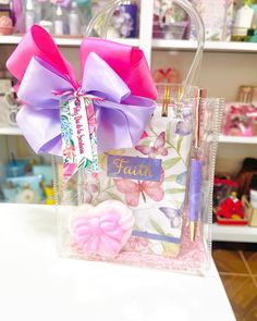 a clear bag with pink and purple bows on the front is sitting on a table