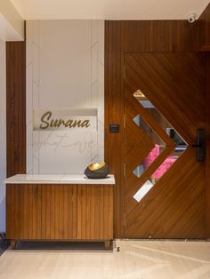 a wooden door with a sign that says sunna on it and a vase in front