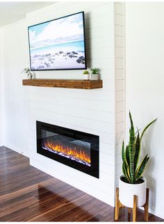 a flat screen tv mounted on the wall above a fireplace