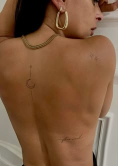 the back of a woman's body with tattoos on her upper and lower back