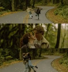 two people walking down a road in the woods, one is kissing the other's face