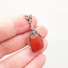 DESCRIPTION: A beautiful antique Georgian solid silver diamond paste pendant, adorned with a genuine carnelian agate gemstone. As to be expected with its age, it isn't stamped/hallmarked, it tests for high grade silver (800+). It weighs approx. 3.98g and the size dimensions are in the later photos. Some of the pastes have darkened with age and use, see pictures/video. The carnelian has some glue on the rear where it's been glued back into its mount, see pictures/video. Mountains of unique antiqu Antique Orange Gemstone Jewelry, Elegant Carnelian Stone Jewelry, Victorian Carnelian Jewelry For Formal Occasions, Antique Oval Carnelian Jewelry, Vintage Carnelian Engraved Jewelry, Elegant Engraved Carnelian Jewelry, Orange Victorian Jewelry For Gift, Antique Carnelian Pendant Necklace, Antique Engraved Carnelian Jewelry