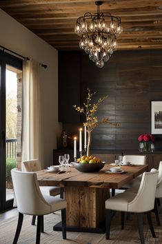 a dining room table with white chairs and a bowl of fruit on the centerpiece