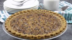 a pie sitting on top of a metal pan next to plates and milk jugs