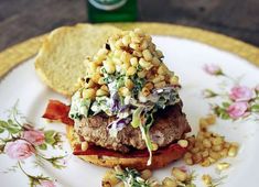 a burger with corn on the cob and lettuce is sitting on a plate