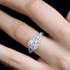 a woman's hand with a diamond engagement ring on her left and right hand