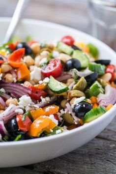 a white bowl filled with salad on top of a wooden table