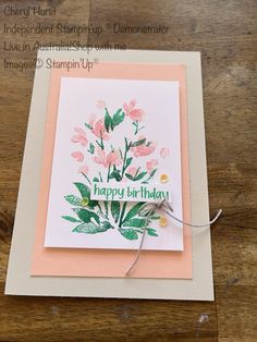 a handmade birthday card with pink flowers on the front and green leaves on the back