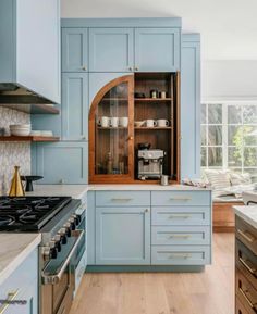 a kitchen with blue cabinets and wooden floors