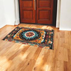 a door mat on the floor in front of a wooden door with two brown doors