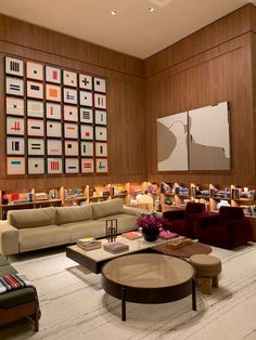 a living room filled with lots of furniture next to a wall covered in bookshelves