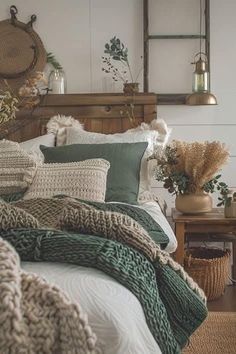 a bed with pillows and blankets on top of it in a room filled with plants