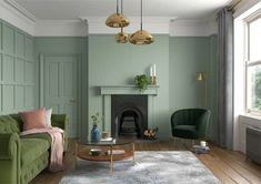 a living room with blue walls and wood flooring, two chairs, a fireplace and a rug on the floor