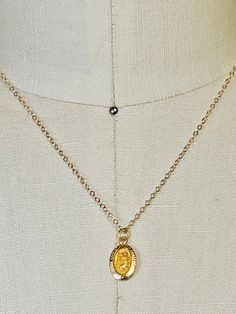 14k solid yellow gold St. Christopher small oval medallion pendant. 14mm (includes measurement of attached ring x 8mm wide. Displayed from a 14k solid gold 16 inch cable  1.5mm chain. Even though this is a smaller delicate chain it's substantial enough to wear alone without the pendant. Total gold weight 1.4 grams. This a smaller pendant that I paired with a 16 inch necklace. If you would like a longer necklace or heavier necklace I have several available in my shop. I can add your pendant to any necklace of your choosing. Message me for prices, length and styles. Please email me if you any questions about this listing or any of my other listings. I will get back to you with-in the day. It helps to take a ruler and use the measurements as a comparison. Item's pictures are enlarged and zoom St Christopher Medal, 16 Inch Necklace, St Christopher, Saint Christopher, Delicate Chain, Oval Pendant, Small Pendant, Solid Yellow, Cable Chain