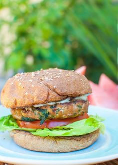 a chicken sandwich with lettuce and tomatoes on a plate