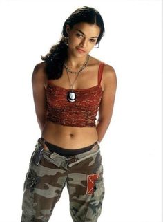 a woman in camo pants and tank top posing for the camera with her hands on her hips