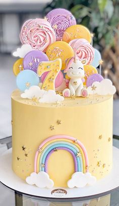 there is a yellow cake with rainbow decorations on it