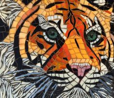 a close up of a tiger face made out of mosaics and glass tiles with green eyes