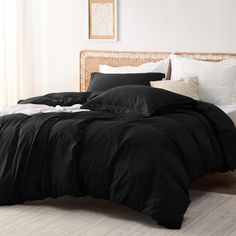 a bed with black sheets and pillows in a room