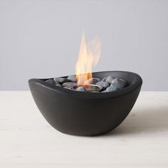 a black bowl filled with rocks on top of a table