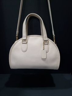 "For your consideration is this beautiful vintage Coach Chadwick Bag, or Bowler (style #9928) in Bone or ivory-white, with brass hardware. It is a \"Leatherware Era\" bag, and was made in the United Sates before 1994. It is in near Mint restored condition. I consider this bag to be the Grail of vintage Coach purses, and is one of the most beautiful bags that Coach made during this era. It is my favorite, and especially rare in bone. The Chadwick satchel is a unique Coach style that is sought aft Vintage White Handheld Shoulder Bag, Vintage White Top Handle Shoulder Bag, Vintage Cream Bags With Detachable Handle, Classic Cream Satchel With Top Handle, Classic Cream Top Handle Satchel, Classic Cream Satchel For Formal Occasions, Classic White Handheld Satchel, Timeless Cream Satchel For Formal Use, Formal Cream Satchel With Handle Drop