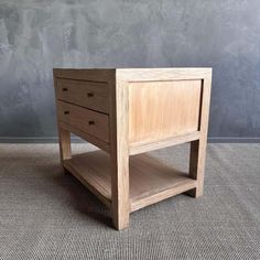 a small wooden table with two drawers on the bottom and one drawer open, sitting on a carpeted floor