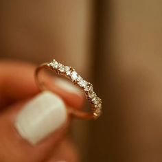 a close up of a person holding a ring with diamonds on it's side