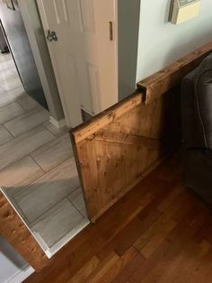 a brown couch sitting on top of a hard wood floor next to a white door