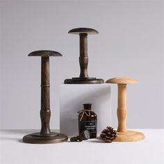 an assortment of wooden objects are displayed on a white surface with a pine cone and bottle in the foreground